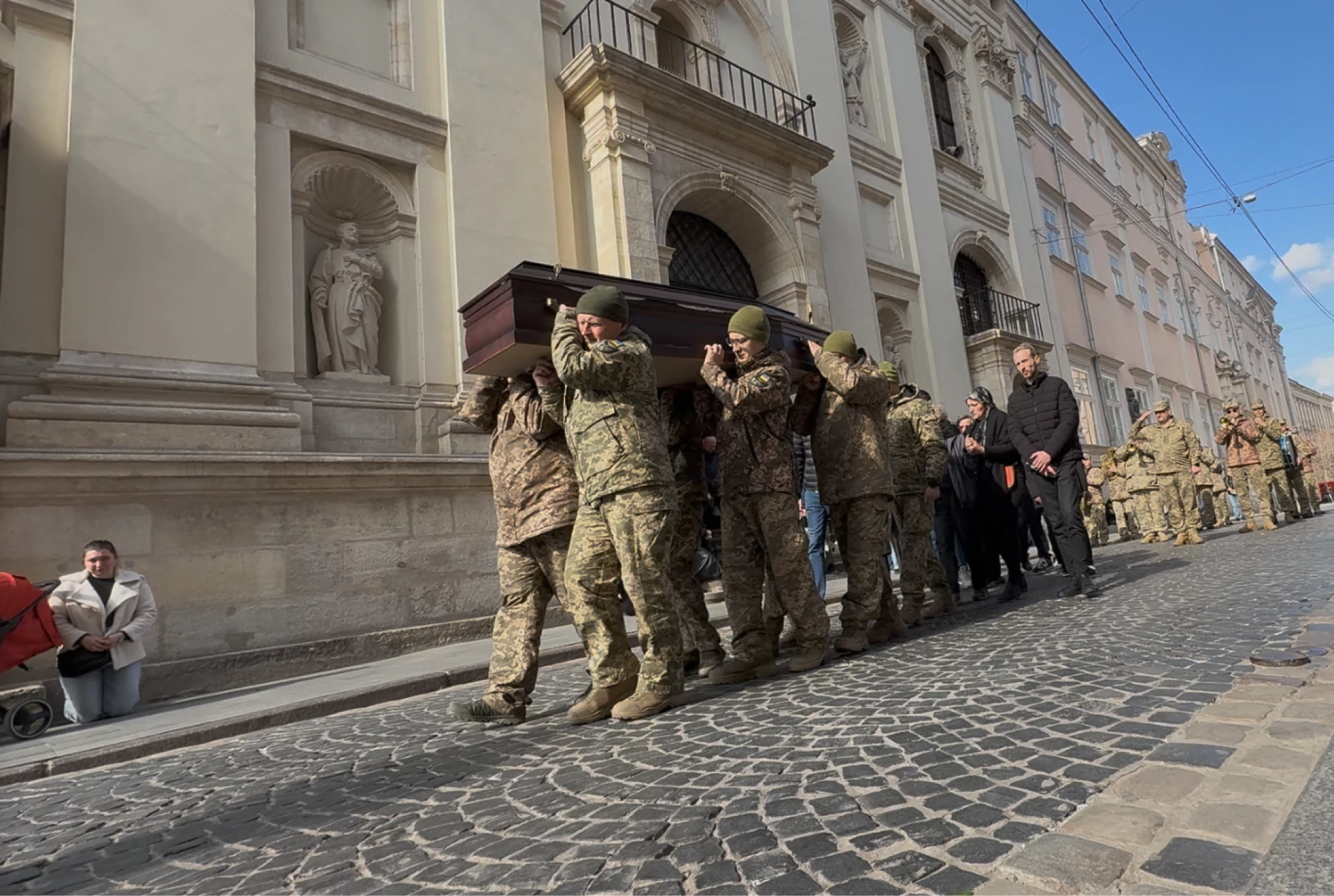 Fallen soldier carried by comrades
